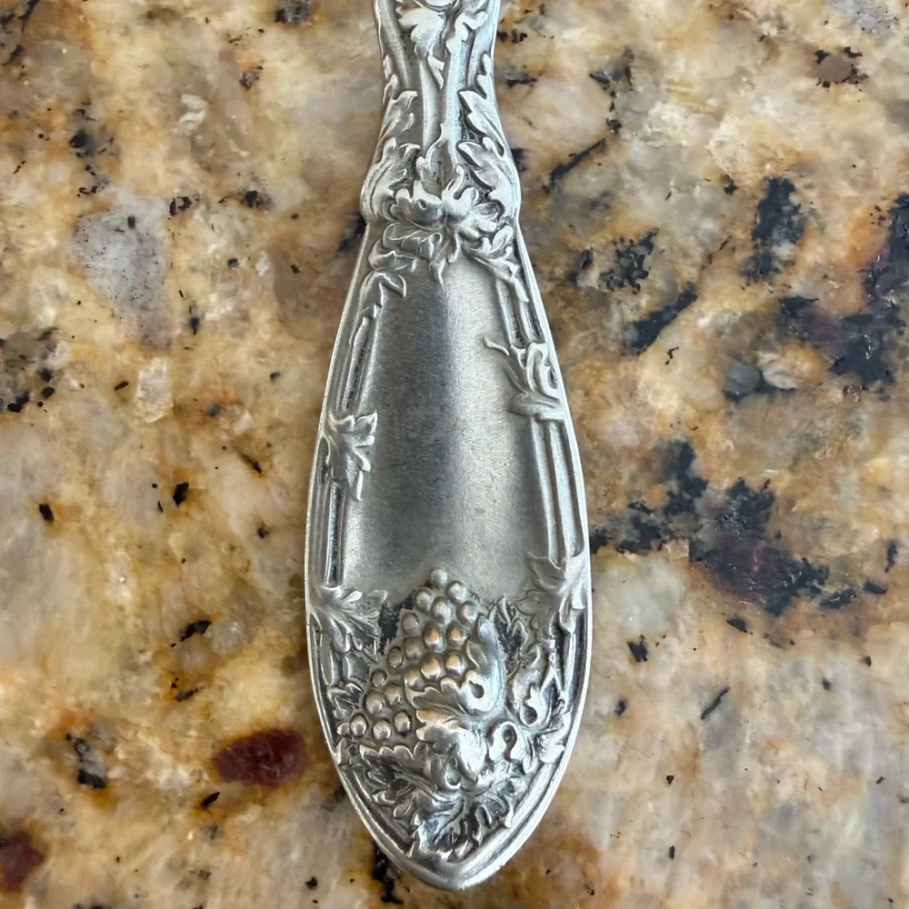 Elegant Silver Serving Spoon with Intricate Design